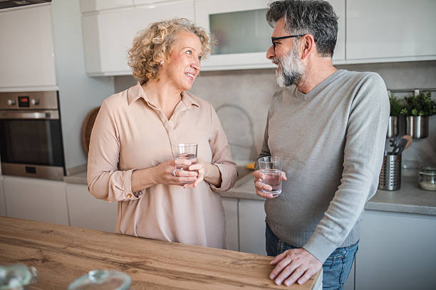 istock Husband and wife are chatting while standing in the kitchen 2207794928