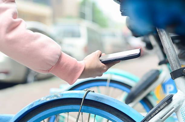 istock Commuter using smart phone to scan the QR code on a shared bike to unlock it. 2207795323
