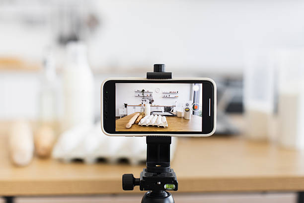 istock Smartphone camera recording video in kitchen with baking ingredients and tripod 2207797203