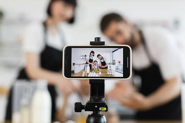 istock Caucasian family creating video content while cooking together in modern kitchen 2207797257