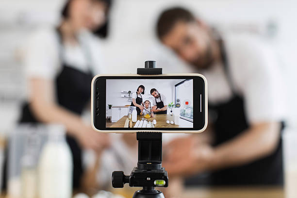 istock Caucasian family recording baking class with smartphone in modern kitchen 2207797264