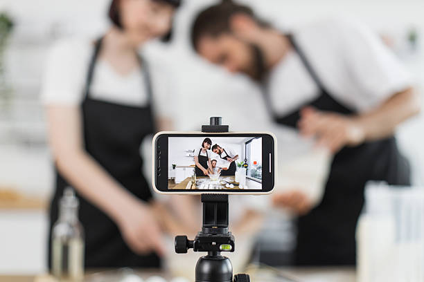 istock Caucasian family recording video while cooking together in bright modern kitchen 2207797274