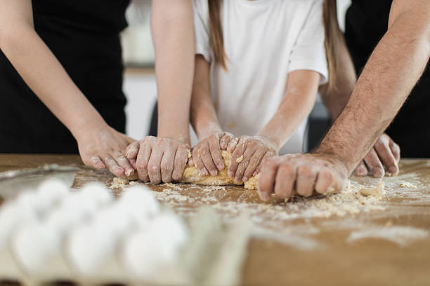 istock Family bonding through cooking and kneading dough together in kitchen 2207797298