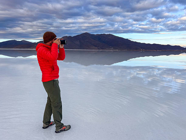 istock Man Capturing Serene Landscape at Sunrise in Vast Desert 2207797783