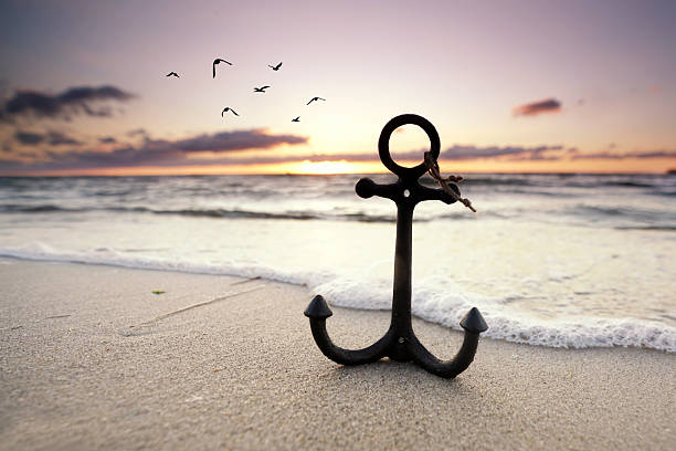 istock beautiful anchor in the snd on the beach in sunset light 2207800758