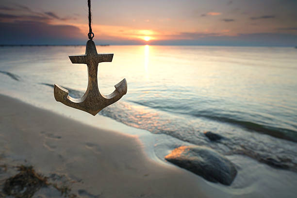 istock unique wooden anchor at the sunset beach 2207800890