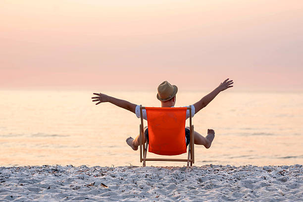 istock recreation at the beach, boy is sitting in a deckchair 2207802120