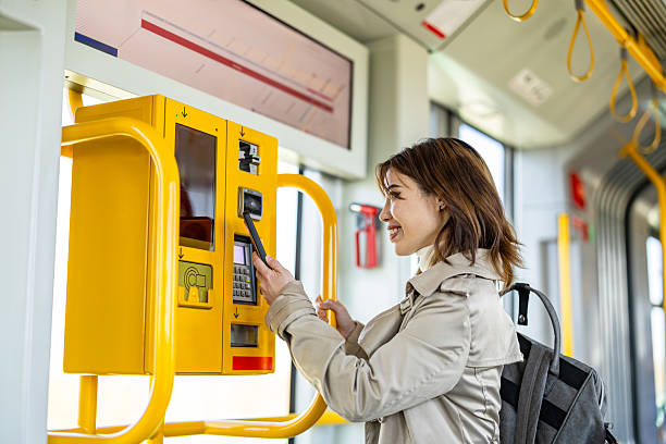 istock Young woman buying a ticket from a machine in a tram 2207802704