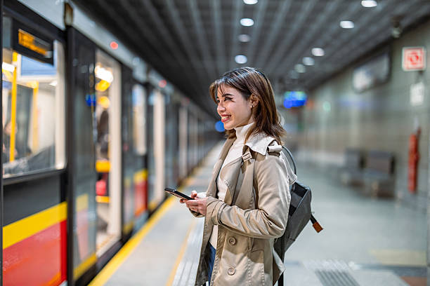 istock Smiling young woman using mobile phone in a public transport 2207802753
