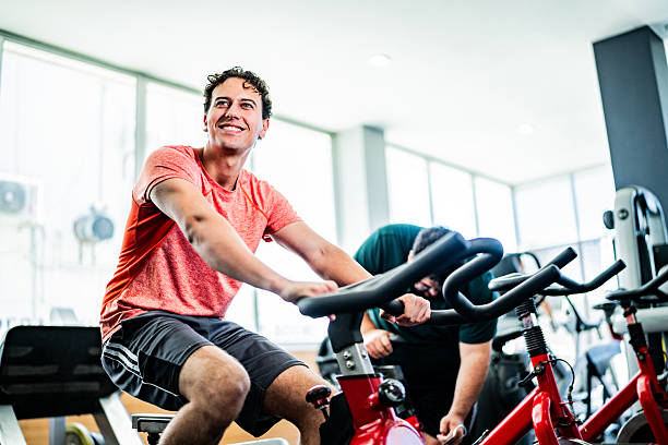 Young man on exercise bike at gym