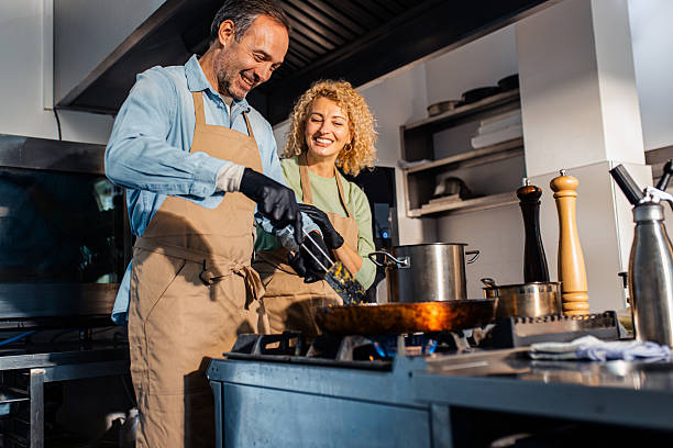 istock Couple enjoying a cooking class with a chef preparing meal in the kitchen. 2207803588