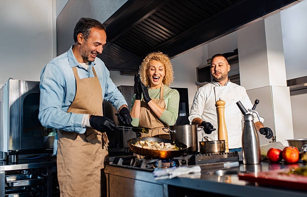 istock Couple enjoying a cooking class with a chef preparing meal in the kitchen. 2207803591