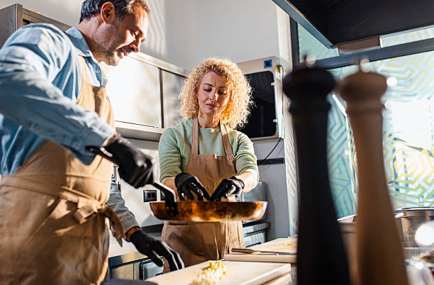 istock Couple enjoying a cooking class with a chef preparing meal in the kitchen. 2207803600