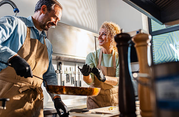 istock Couple enjoying a cooking class with a chef preparing meal in the kitchen. 2207803605