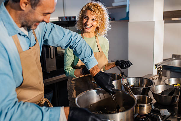 istock Couple enjoying a cooking class with a chef preparing meal in the kitchen. 2207803714