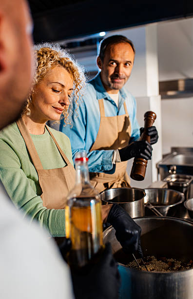 istock Couple enjoying a cooking class with a chef preparing meal in the kitchen. 2207803726