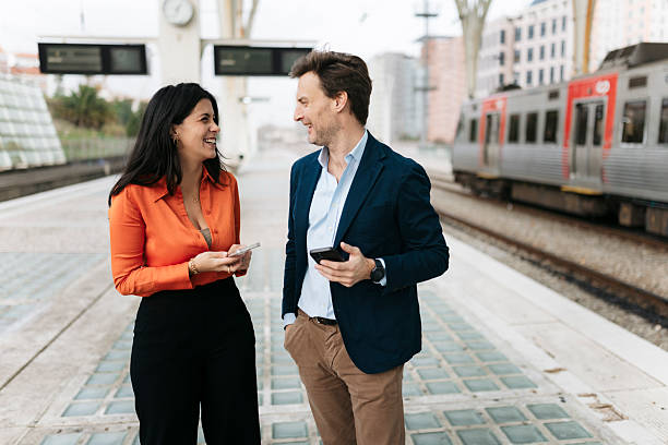 istock Business people talking and smiling at train station platform 2207803775
