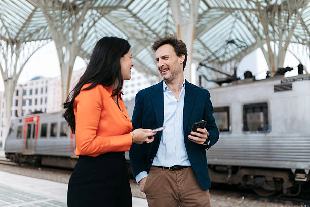 istock Business people talking and smiling at train station 2207804611
