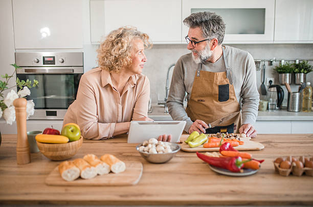 istock A cheerful mature couple uses a digital tablet and smart technology while preparing a healthy lunch in the kitchen 2207805284