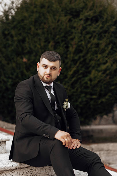 istock A man in a suit and tie sits on a stone step 2207806685
