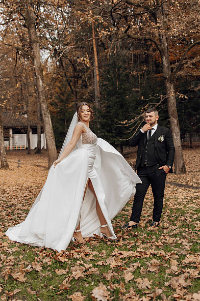 istock A bride and groom are posing for a picture in a park 2207806704