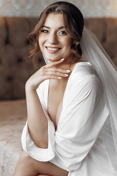 istock A woman is sitting on a bed and smiling 2207807084
