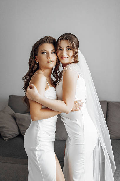 istock Two women in white dresses are hugging each other 2207807182