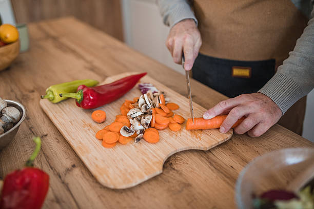 istock Unrecognizable man preparing lunch in the kitchen at the kitchen counter, chopping vegetables 2207807763
