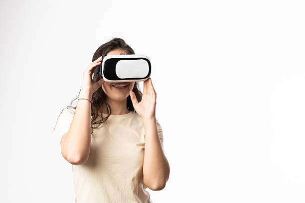 istock Young woman exploring virtual reality with headset and smiling 2207808498