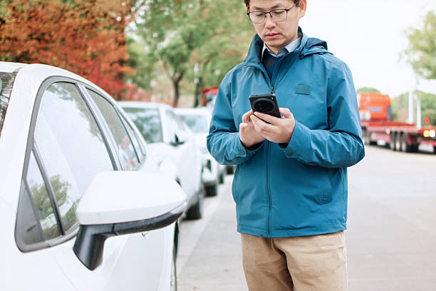 istock asian man using smart phone  open door of car 2207808590