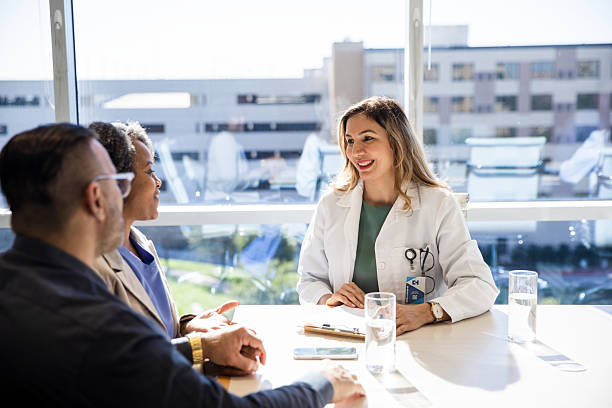 istock Doctor Consulting with Couple in Bright Office 2207813459