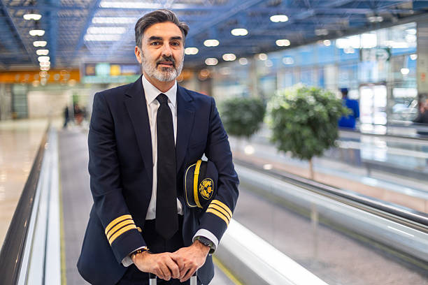 istock Confident airline pilot standing in airport terminal 2207816517