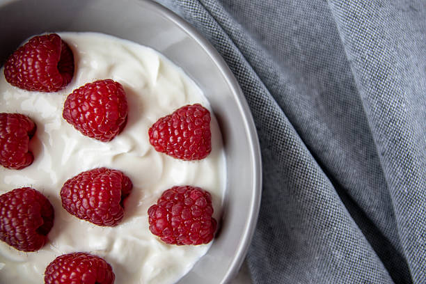istock Gray bowl and natural yogurt with berries on the stone marble table. 2207816788