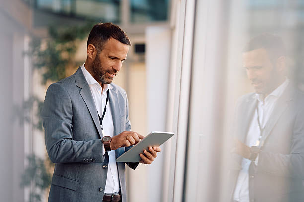 istock Smiling businessman working on touchpad in the office. 2207820577