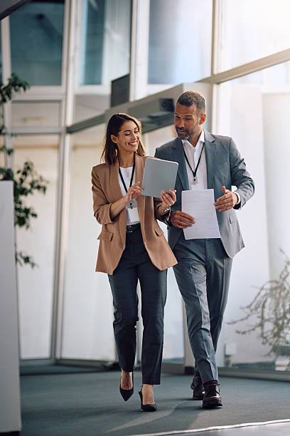 Smiling colleagues cooperating while working on touchpad in the office. stock photo