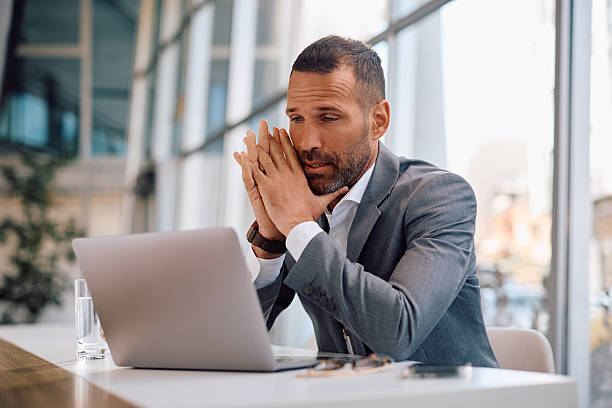 istock Displeased businessman reading an e-mail on laptop in the office. 2207821019