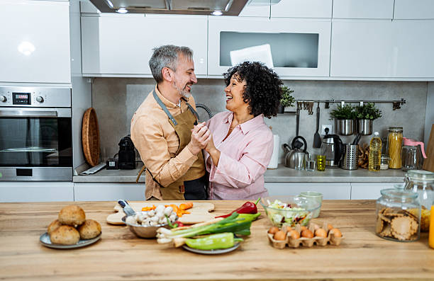 istock Playful mature couple dancing in the kitchen at home 2207823037
