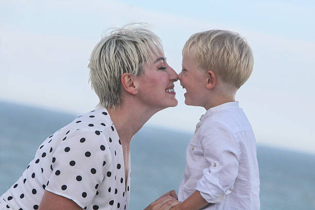 portrait of cheerful mother and her toddler son outdoors bonding