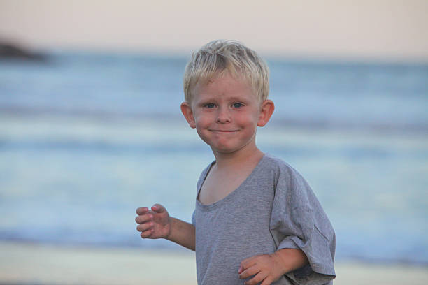 portrait of cheerful little boy on the beach at dawn