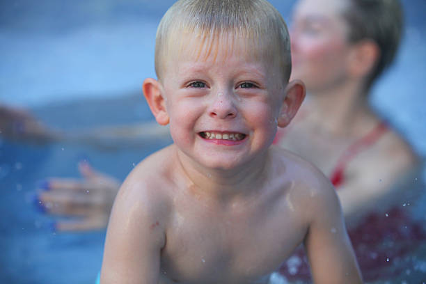 portrait of cheerful little boy in swimming pool  getting cold