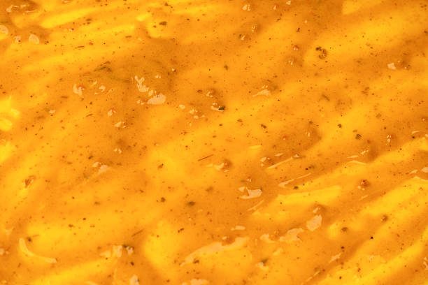 Yellow sauce splashes as a background. Top view.