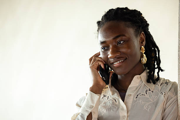 Young woman with dreadlocks hairstyle have cellphone on stairs