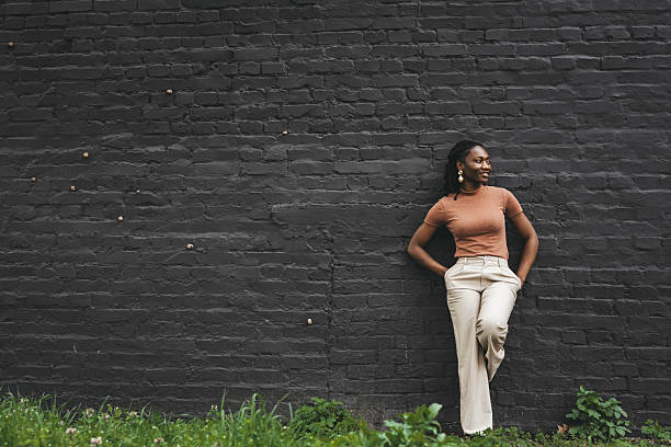 istock girl leaning against a large brick wall 2207826887