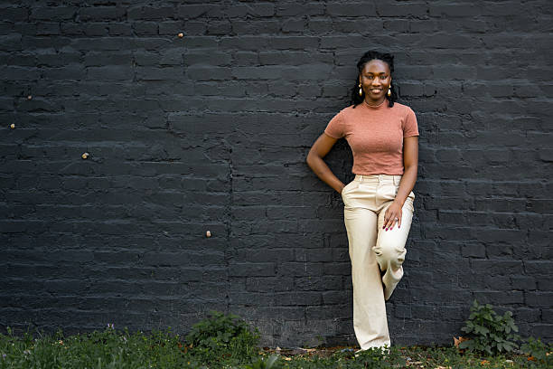 istock girl leaning against a large brick wall 2207827039