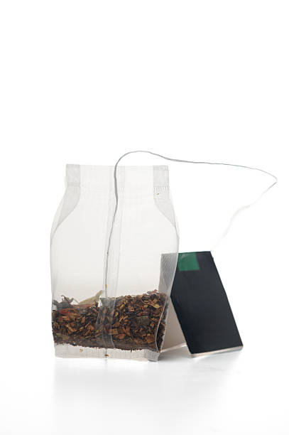 istock Delicate herbal tea steeping in a transparent bag beside an empty tea tag waiting for a warm cup to be brewed 2207827418