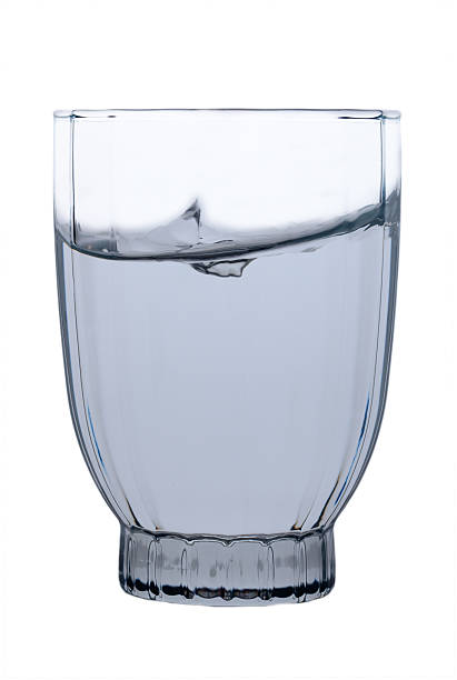 istock Clear water splashes artfully within a versatile glass strikingly backlit against a simple background 2207828056