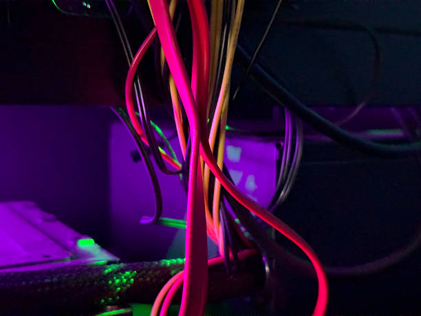 istock Brightly colored cables are intertwined and glowing under purple light in a tech workspace 2207829900