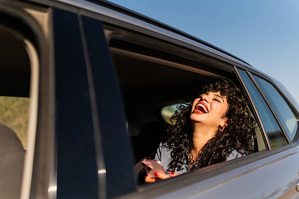 istock Young woman using mobile phone inside a taxi 2207831446
