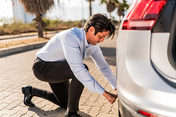 istock Mid adult man changing flat tire on the road 2207831462
