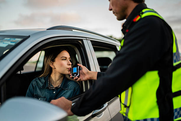istock Young woman doing driver alcohol test on street 2207832747
